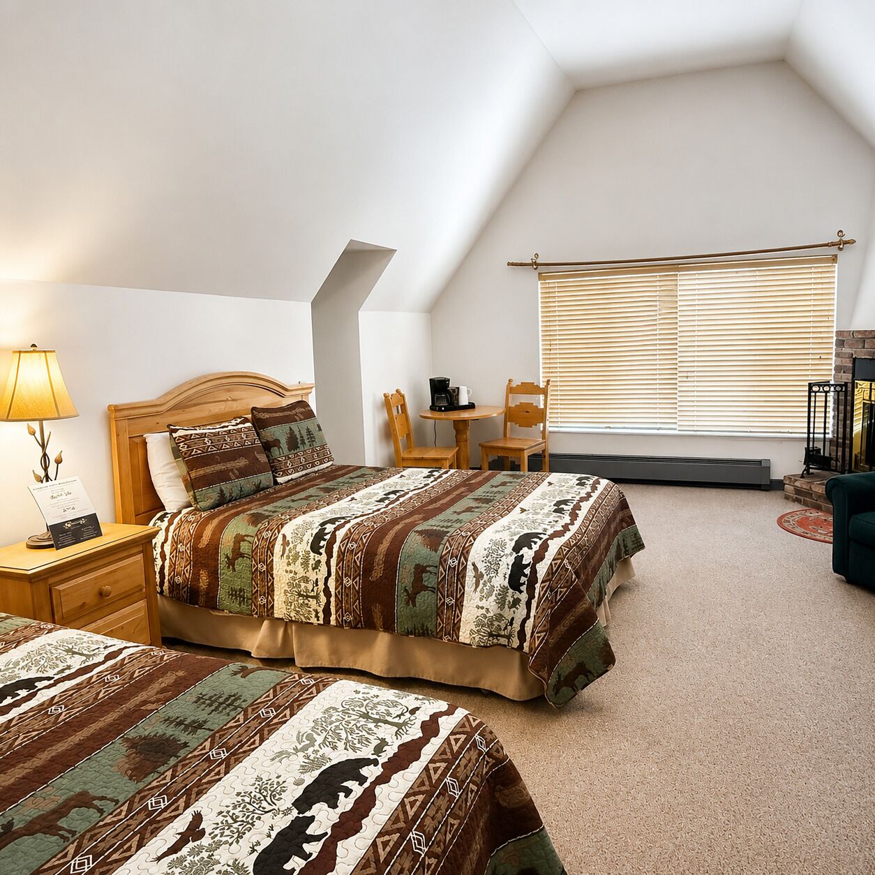 A bedroom with a bed, bedside table, lamp, and a small table with chairs.