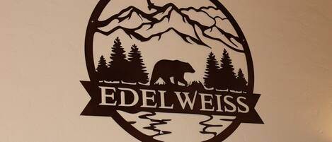 Un adesivo da parete con un paesaggio montano e un orso, con la scritta 'Edelweiss' sotto.