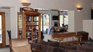 Un soggiorno accogliente con una grande libreria in legno, una poltrona comoda e un divano.