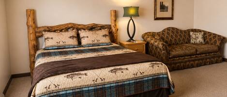 A bedroom with a bed, a chair, a lamp, and a ceiling fan.