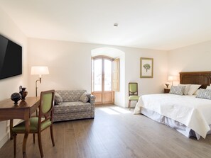 A hotel room with a bed, a sofa, a desk, and a chair. - Hospedium Hotel La Lozana (Used)