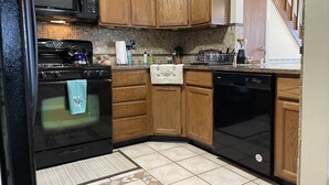 A kitchen with wooden cabinets, a microwave, stove, oven, and dishwasher.