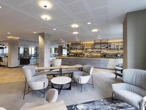 A modern bar area with seating, a bar counter, and a patterned rug. - Novotel Liverpool Paddington Village (Liverpool)