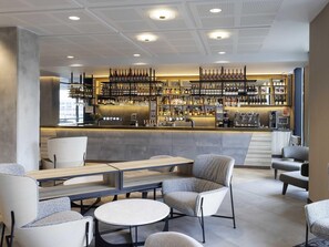 A bar area with seating, a counter with a wine display, and a staircase. - Novotel Liverpool Paddington Village (Liverpool)