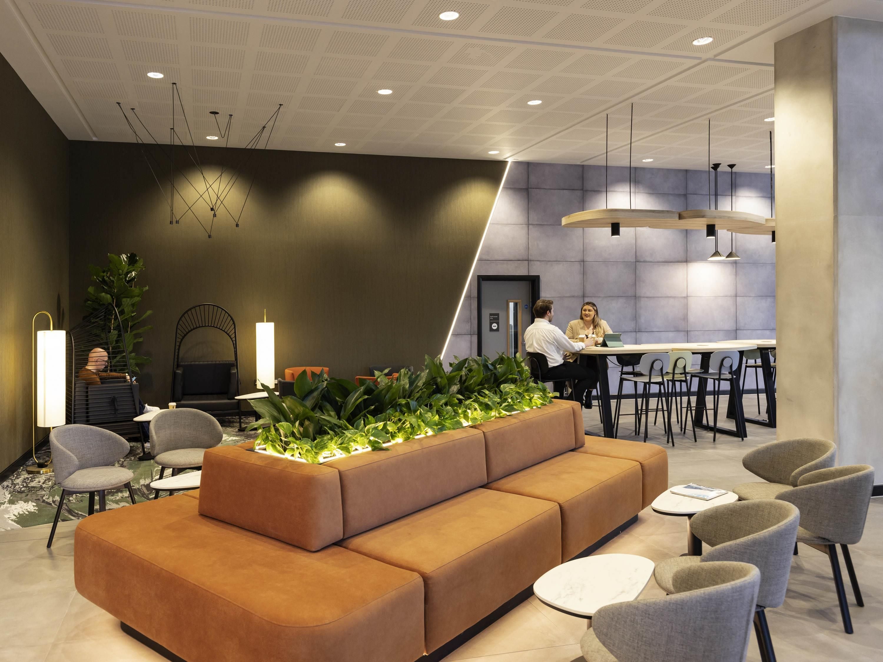 A modern lobby with a sectional sofa, seating area, and a reception desk.