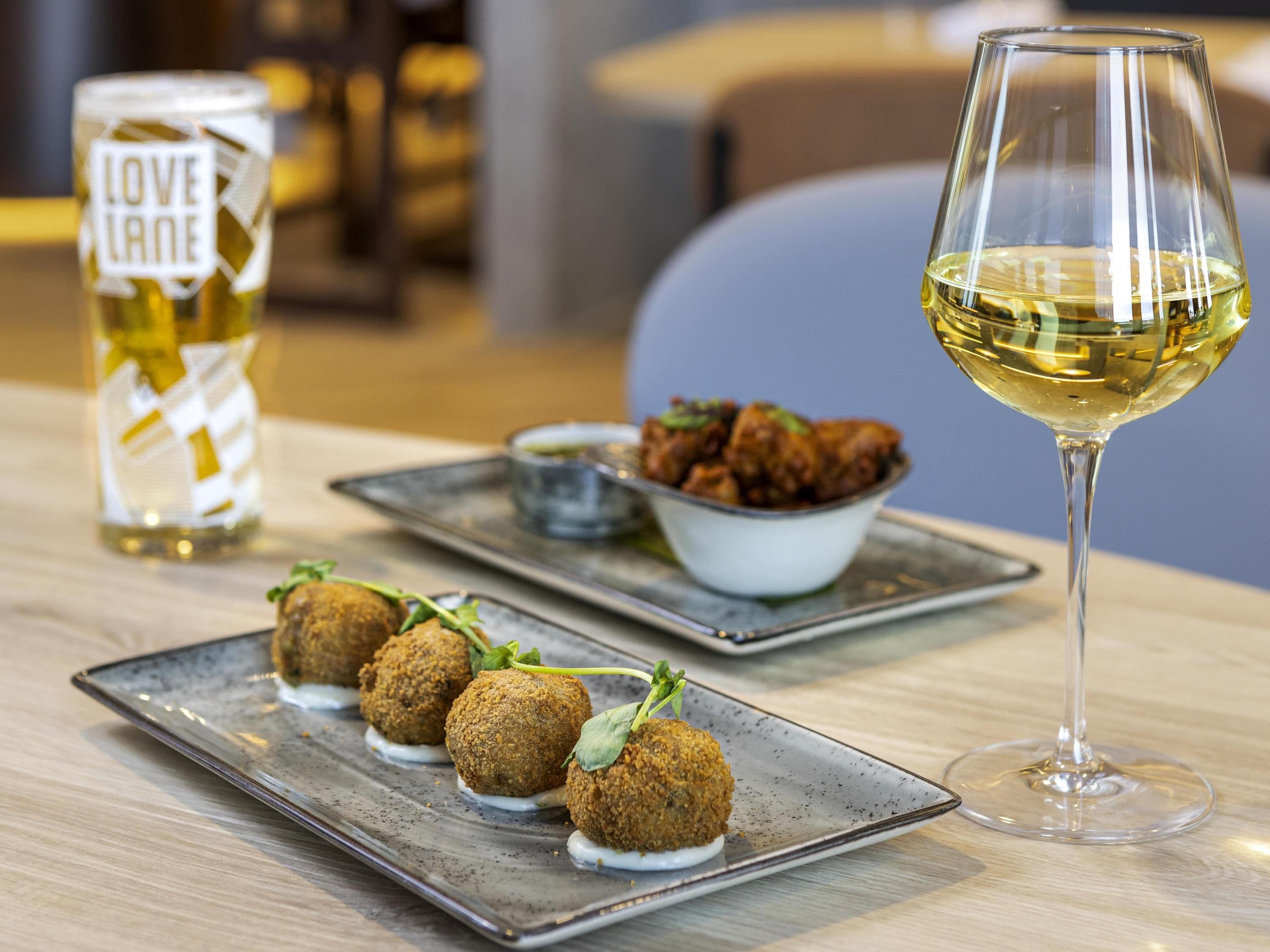 Una mesa de comedor con un plato de comida, una copa de vino y una botella de vino.