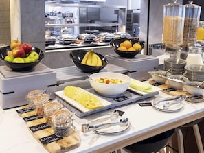 Montaje de bufé con frutas, recipientes y salsas.