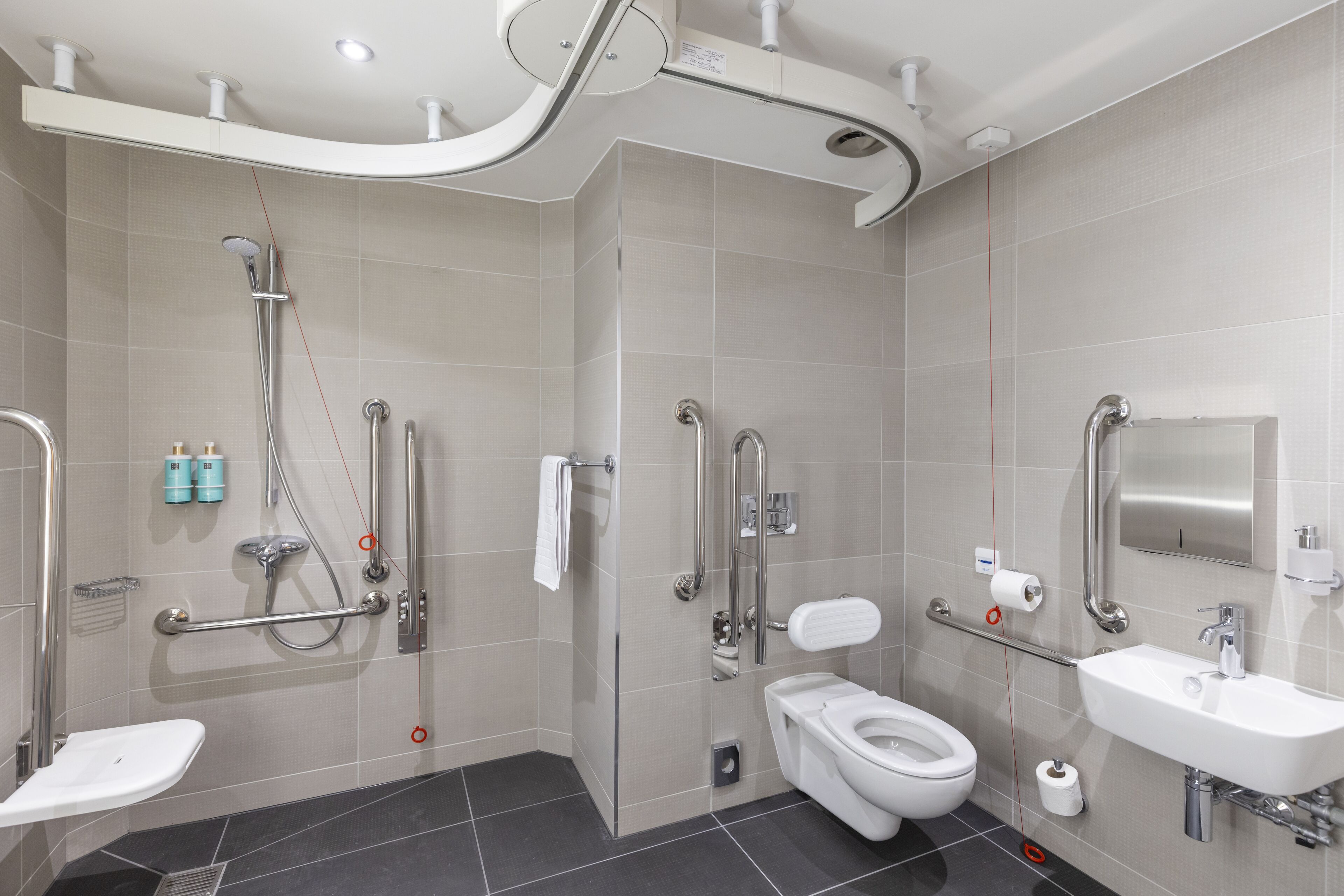 A modern bathroom with a shower, toilet, and sink.