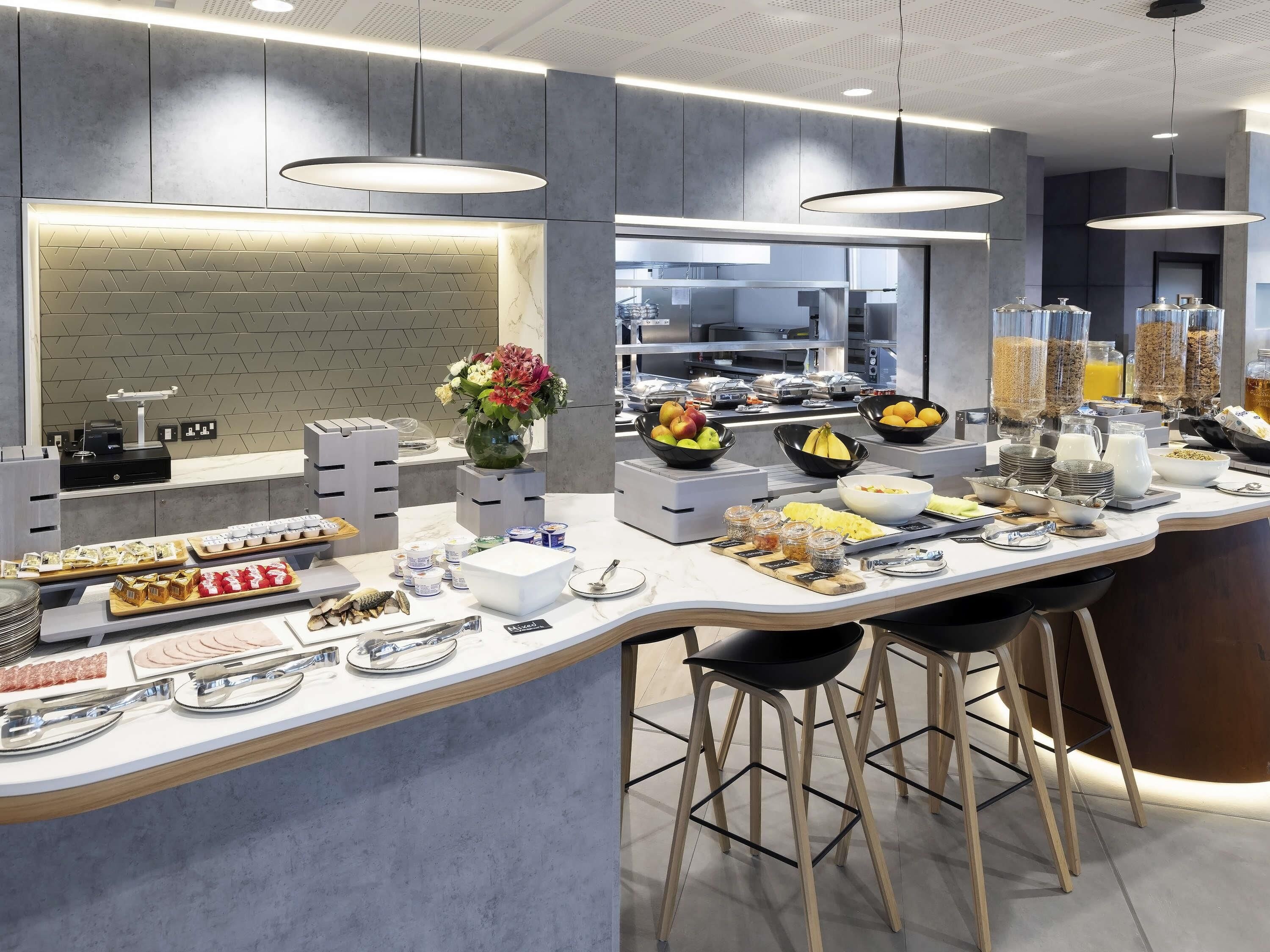 Un bar à petit-déjeuner moderne proposant une grande variété d'aliments, notamment des fruits, des céréales et des boissons.