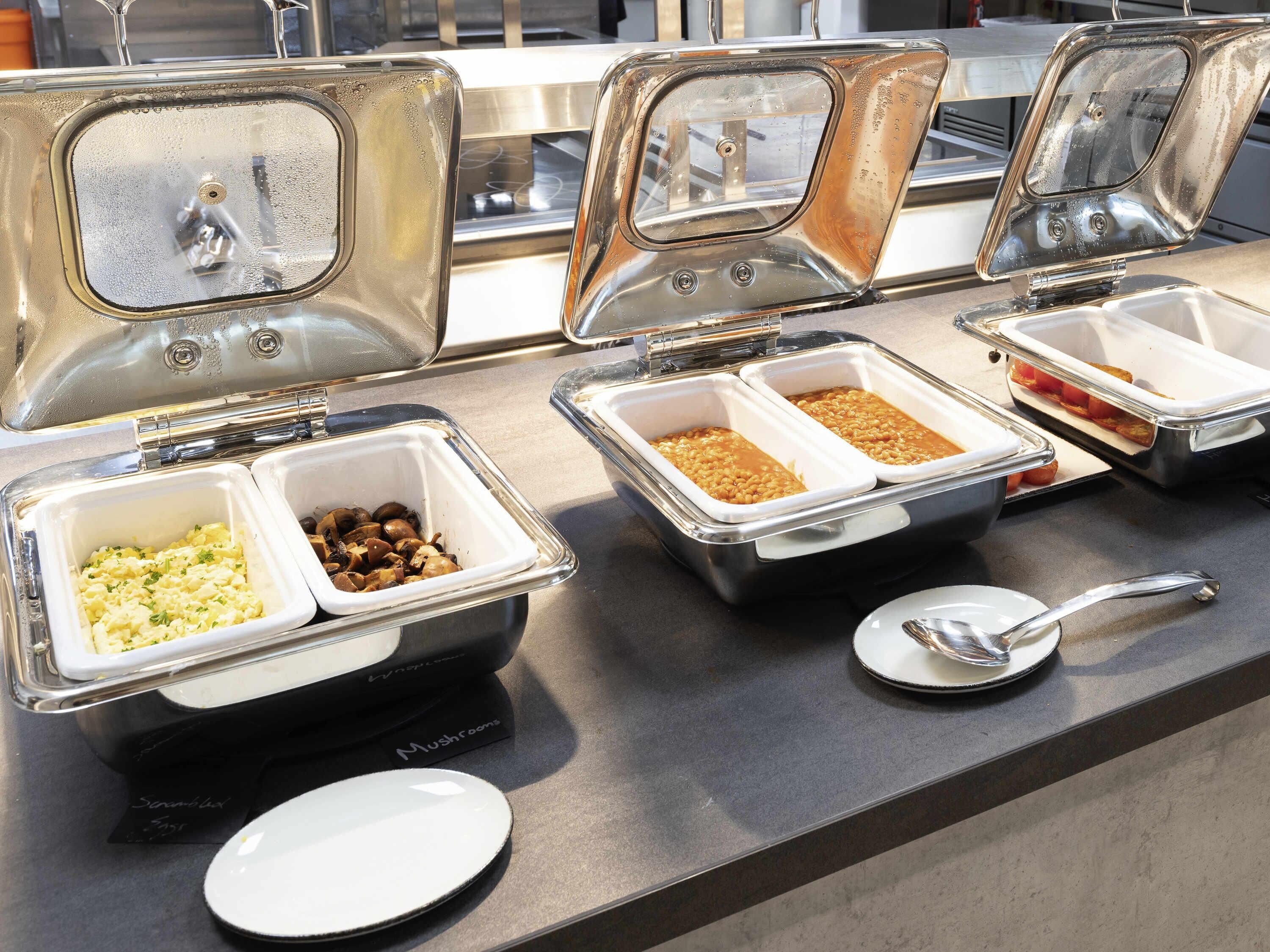 Un buffet avec différents récipients contenant de la nourriture et une cuillère.