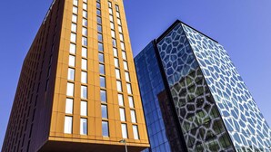 Two modern high-rise buildings with a clear blue sky in the background.