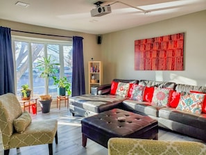 A modern living room with a sofa set, a coffee table, and a bookshelf.