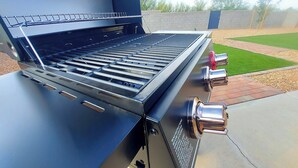 A stainless steel barbecue grill with multiple burners and a side table. - Clean & quiet retreat with private backyard near shopping & trails. (Tucson)