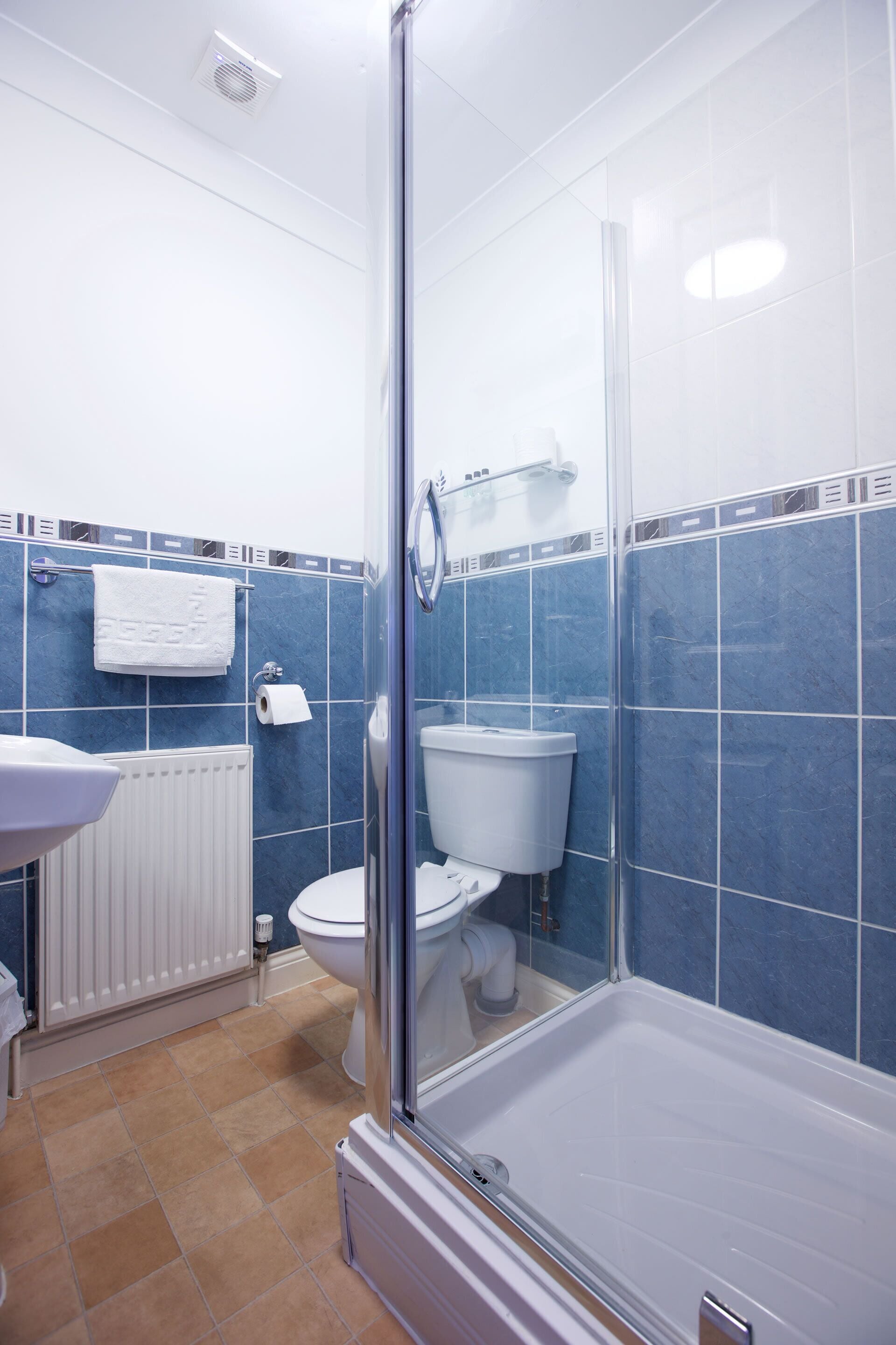 Un baño con ducha, inodoro y lavamanos.
