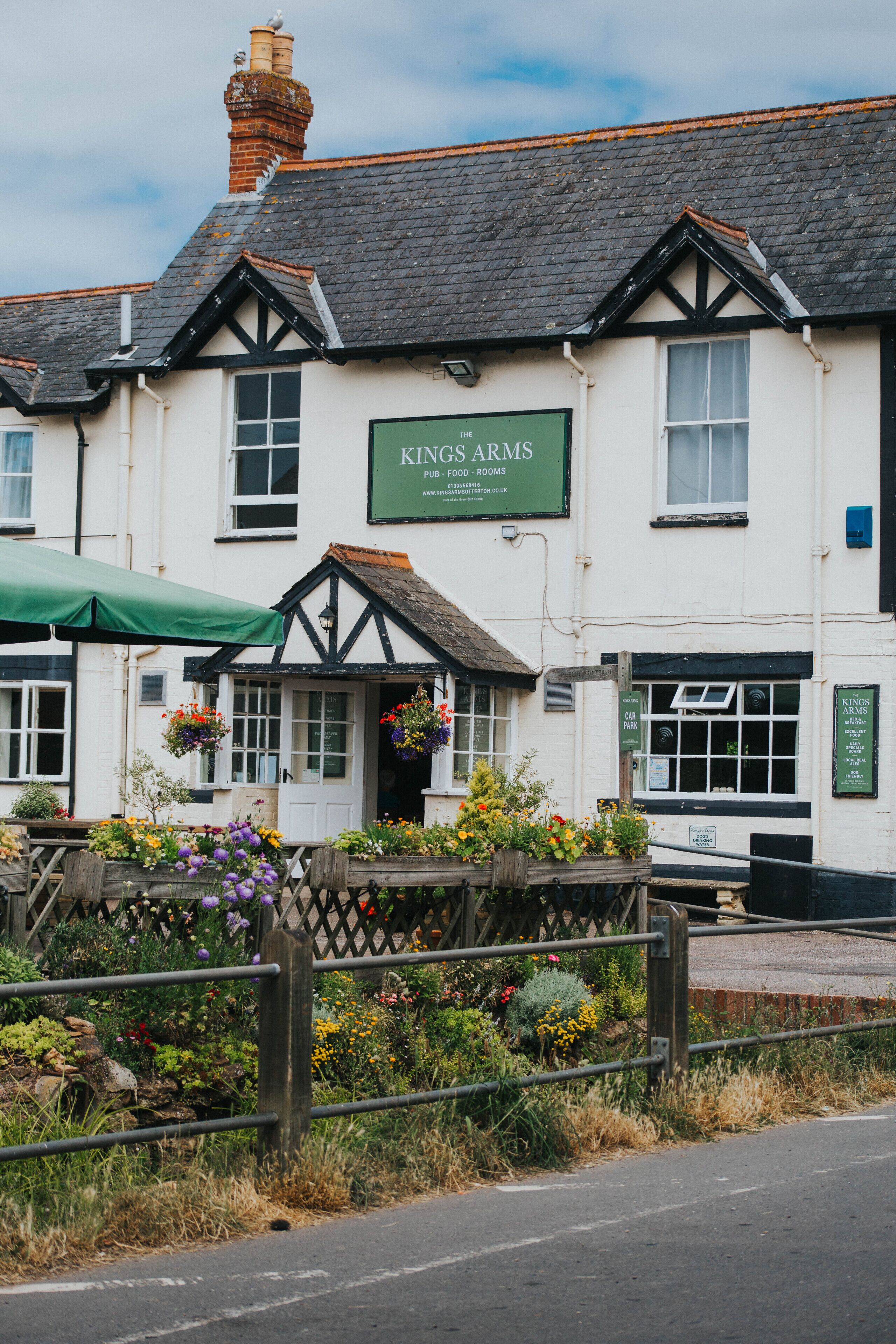 A traditional pub with a sign reading "Kings Arms Pub Food - Rooms".