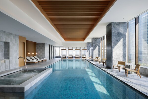 A modern indoor swimming pool with lounge chairs and a wooden ceiling. - The Westin Yokohama (Yokohama)