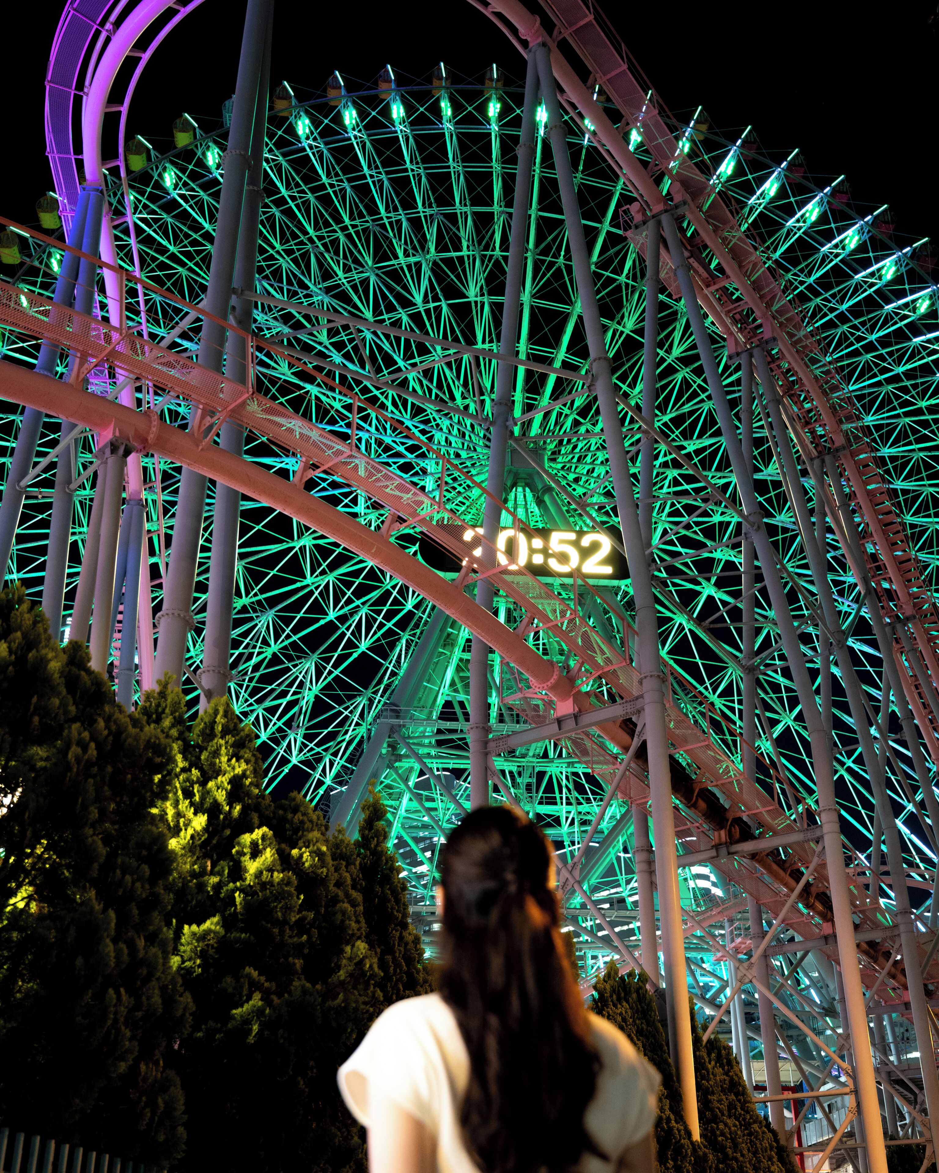 A large Ferris wheel with a digital clock displaying 0:52.