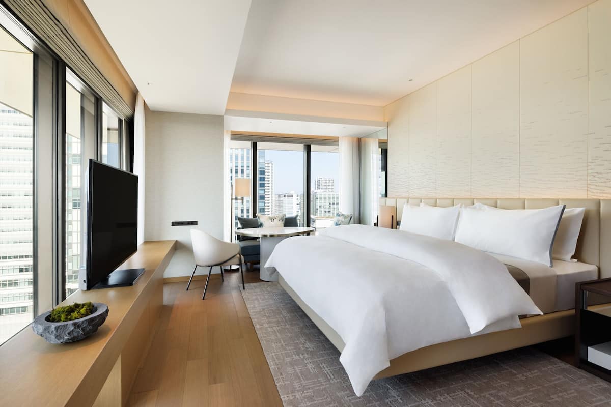 Habitació d'hotel moderna amb un llit gran, un escriptori i una televisió.