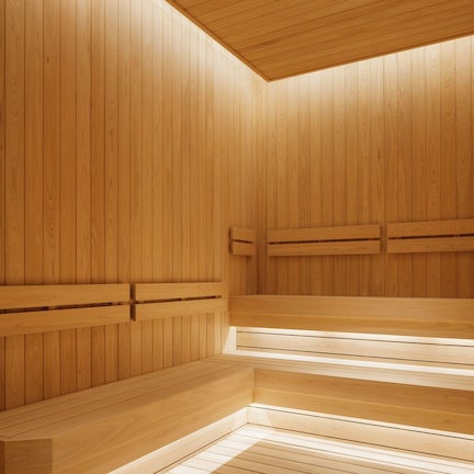 A wooden sauna with benches and a sloped ceiling.