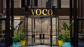 A modern building entrance with a revolving door and the name "VOCO" displayed above. - voco Dubai the Palm by IHG (Dubai)