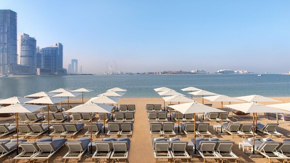 Privat strand, vit sandstrand, solstolar och parasoller