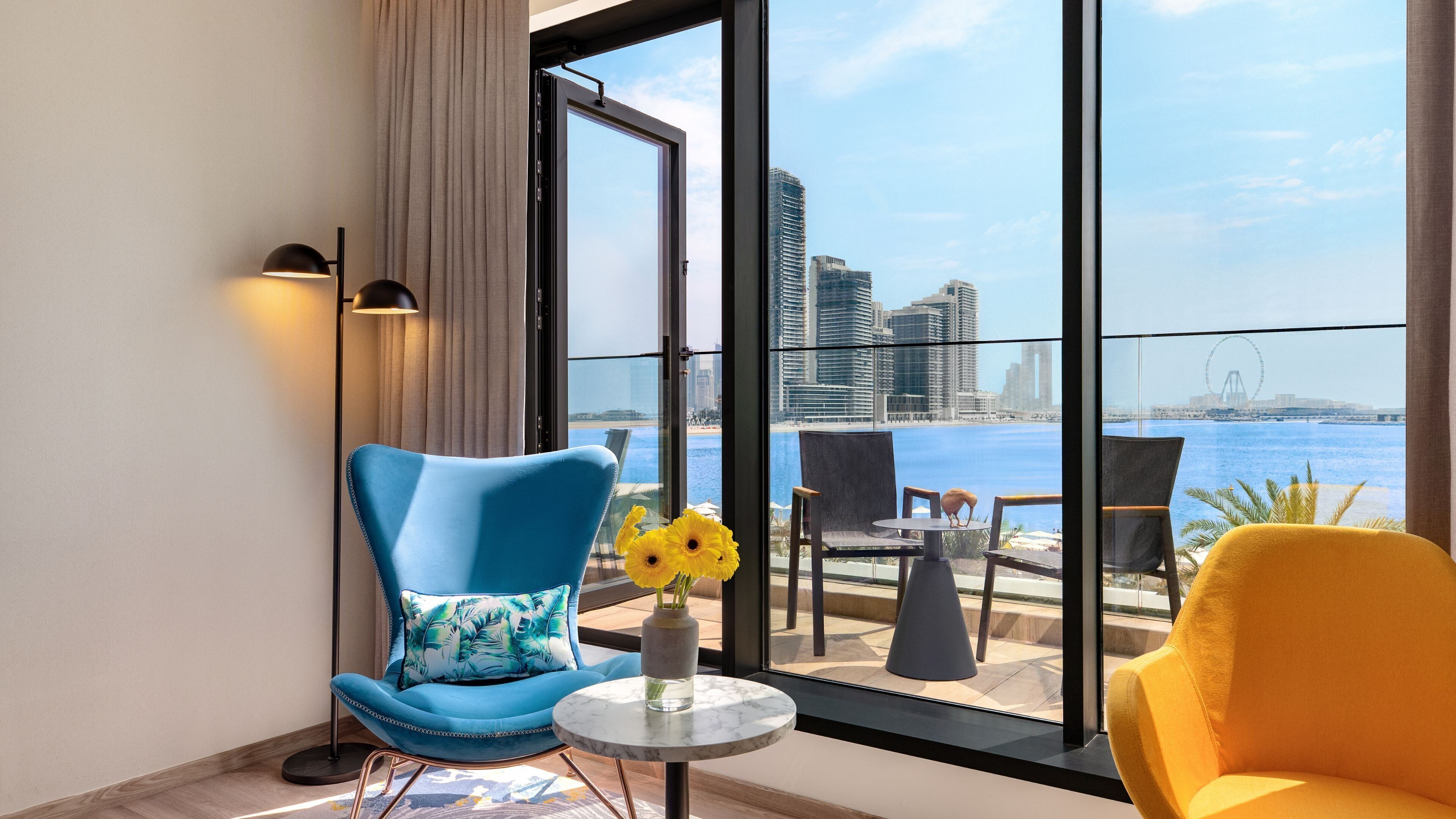 Une chambre moderne offrant une vue sur les toits de la ville et sur l’eau.