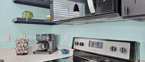 Una cocina moderna con cafetera, horno y microondas.