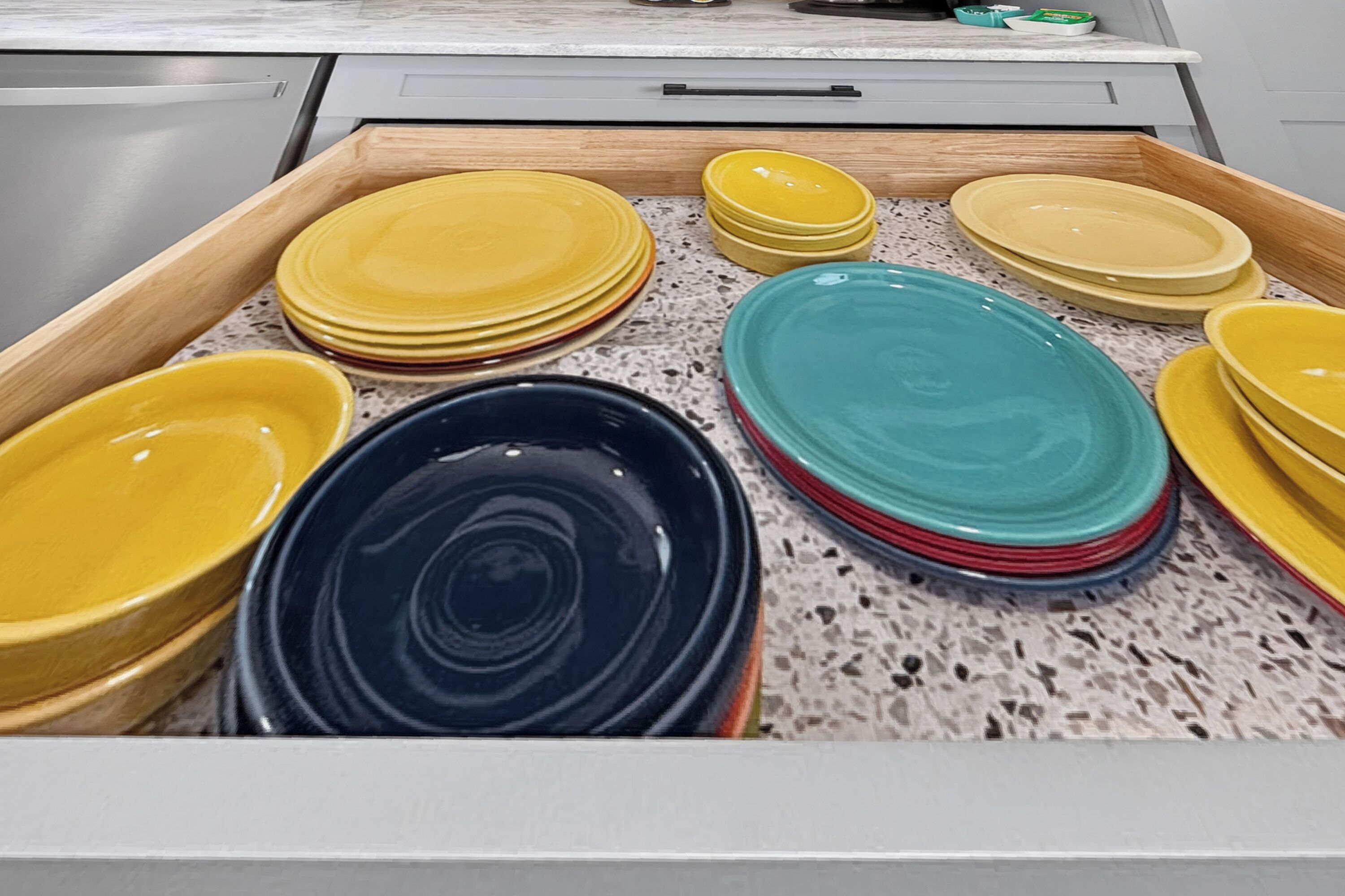 A drawer containing various plates and bowls.
