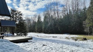 A snow-covered outdoor area with a wooden deck and a building with a sloped roof. - Elkhorn (Packwood)