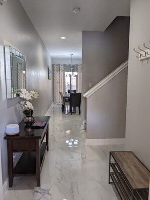 Stunning hallway leads to a beautifully set dining area with a table for two.