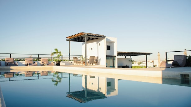 A modern pool area with lounge chairs and a small pavilion. - Torre Diez by Grupo Amber (Playa del Carmen)