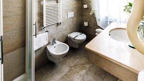 A bathroom with a bidet, toilet, and sink. - Hotel Baviera (Chioggia)