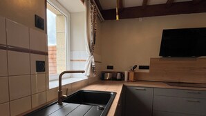 A modern kitchen with a black sink, wooden countertop, and a built-in oven. - Old farmhouse 100m², quiet, 500 m from the beach, sleeps 6-9 (Saint-Michel-en-Grève)