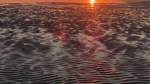 A sunset over a calm sea with gentle waves. - Old farmhouse 100m², quiet, 500 m from the beach, sleeps 6-9 (Saint-Michel-en-Grève)