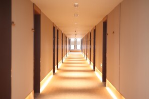 A long, narrow hotel corridor with doors on both sides, leading to rooms. - Ji Hotel (Hangzhou)