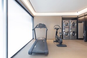 Kuntosali, jossa on juoksumatto, crosstrainer ja useita kuntopyörää.