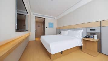 Una camera d'albergo con un letto, un comodino e una finestra.