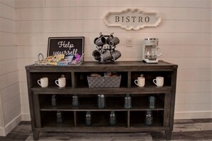 Ein Holzkonsolentisch mit Tassen, einer Kaffeemaschine und einem Schild mit der Aufschrift 'BISTRO'.