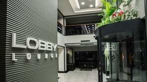 A lobby with a modern design, featuring a sign that reads "Lobby Lounge" and a glass elevator. - Şehrar Suit Hotel (Surmene)