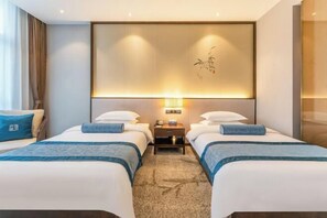 A hotel room with two beds, a nightstand, a wall-mounted lamp, and a decorative wall piece. - Fusheng Jiayue Hotel (Tai'an)