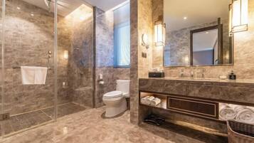 A modern bathroom with a glass-enclosed shower, a toilet, a vanity with a mirror, and a towel rack.