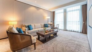 Une chambre d’hôtel moderne, équipée d’un canapé, d’un fauteuil et d’une table basse.