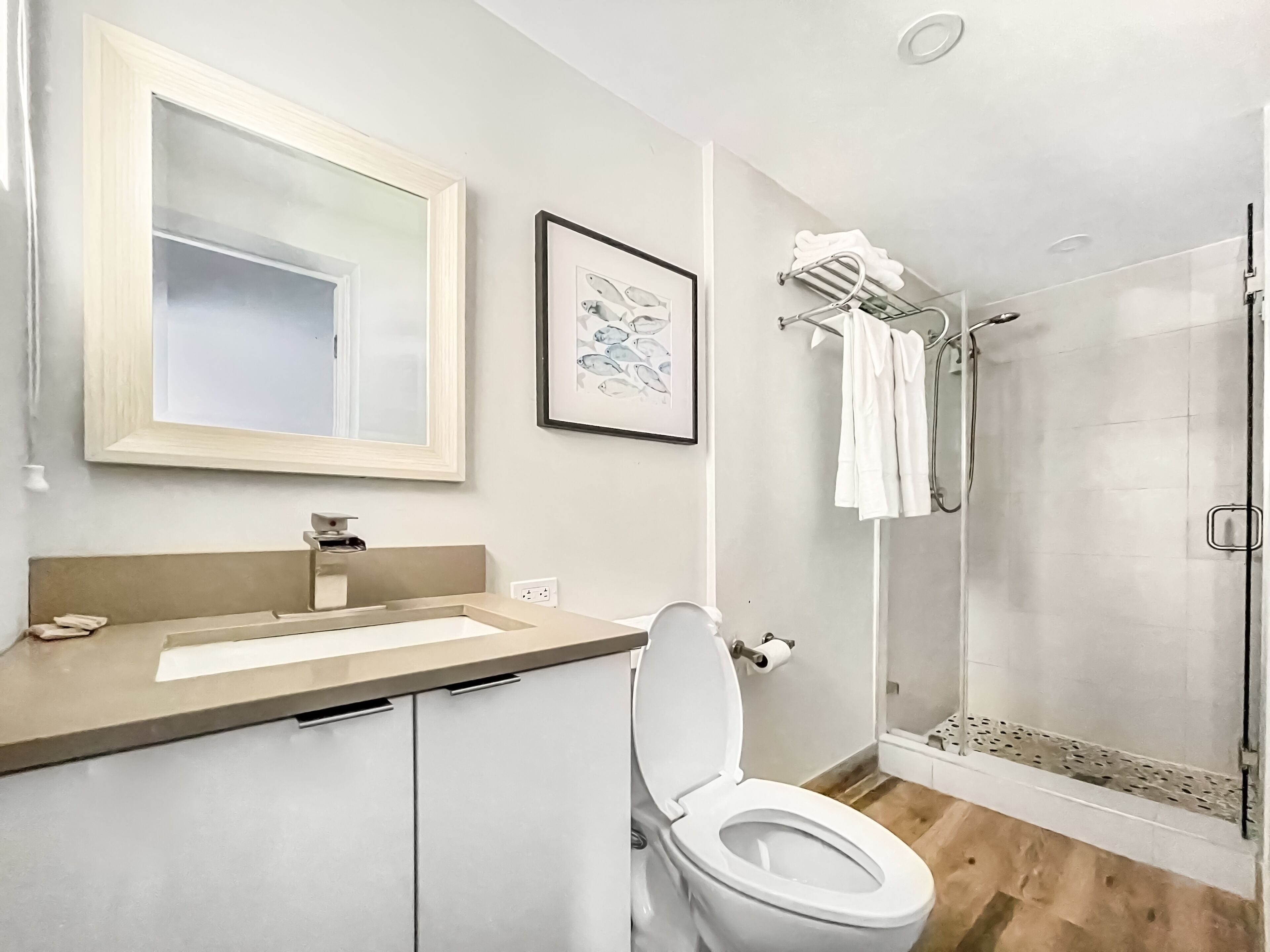Een moderne badkamer met toilet, wastafel en douche.