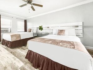 A hotel room with two beds, a ceiling fan, and a window with blinds. - Neptune Oceanfront Rentals (Hollywood)