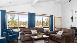 Ein Wohnzimmer mit einem braunen Ledersofa, einem blauen Sessel und einem Holztisch.