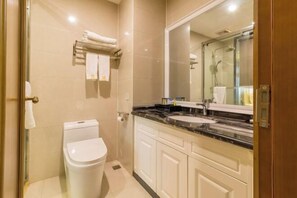 A modern bathroom with a toilet, sink, and mirror. - Mingshi Hotel (Xingan)