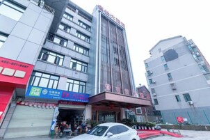 Un edificio de varios pisos con una entrada destacada y señalización para un comercio.