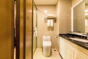 A modern bathroom with a toilet, a sink, and a large mirror. - Mingshi Hotel (Xingan)