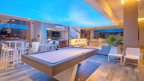 A pool table in a modern indoor setting with a bar area and seating. - Loft 268 "Beautiful Modern Condominium" in  Romantic Zone, Puerto Vallarta. (Puerto Vallarta)