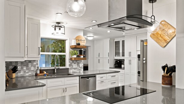A modern kitchen with white cabinets, a black countertop, and a built-in stove. - NEW Naples Modern Farmhouse w/Heated Pool, Sleep 10 (Naples)